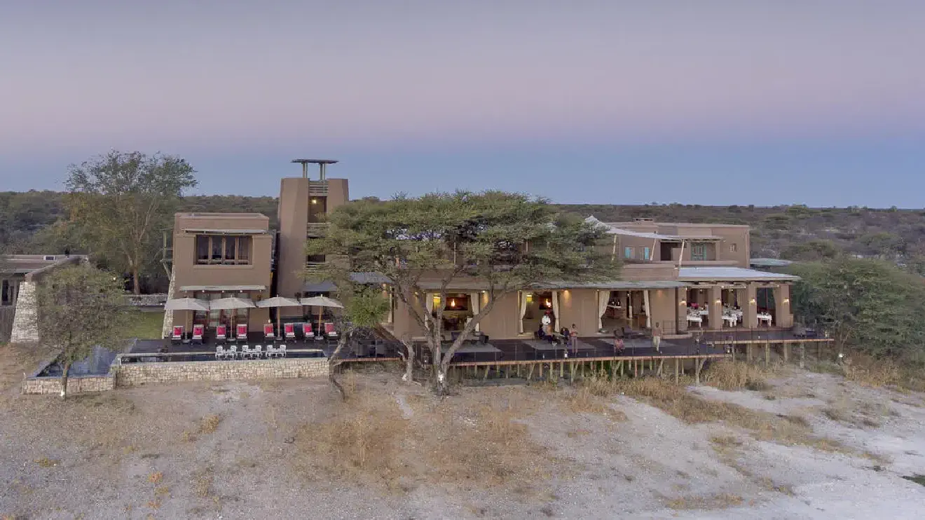 erial view of Onguma lodge's contemporary architecture and open-air deck near Etosha at dusk